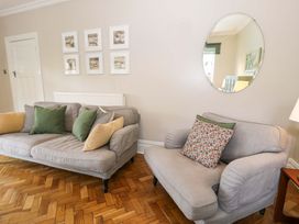 A living room with a sofa and wall art at Coedfryn in Betws-y-Coed
