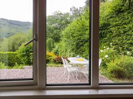 A garden view with a table and chairs at Coedfryn in Betws-y-Coed