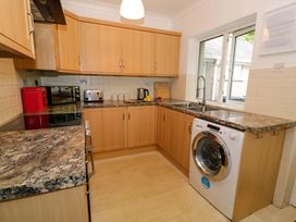 A kitchen with a washing machine and various appliances at Coedfryn in Betws-y-Coed