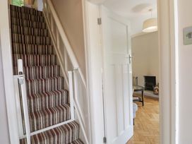 A hallway with a staircase and a door leading to a living area at Coedfryn in Betws-y-Coed