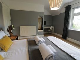 A bedroom with a bed and a desk at Coedfryn in Betws-y-Coed