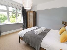 A bedroom with a bed and cushions at Coedfryn in Betws-y-Coed