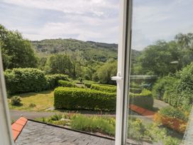 A view from a window showing greenery and hills at Coedfryn in Betws-y-Coed