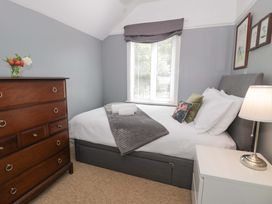 A bedroom with a bed and dresser at Coedfryn Betws-y-Coed