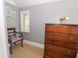 A bedroom with a chair and a dresser at Coedfryn in Betws-y-Coed