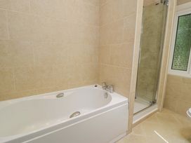 A bathroom featuring a bathtub and a shower at Coedfryn, Betws-y-Coed