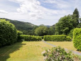 A garden with neatly trimmed hedges and a pathway at Coedfryn in Betws-y-Coed