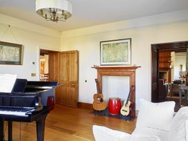 A living room with a piano and guitars at Great Bidlake Manor, Bridestowe, near Lydford