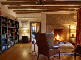 A living room with a fireplace and bookshelf at Great Bidlake Manor in Bridestowe, near Lydford