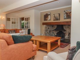 A living room with a sofa, coffee table, and fireplace at Sandsgate in Spinster's Rock, near Chagford