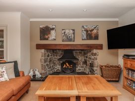A living room with a fireplace and television at Sandsgate near Spinster's Rock, near Chagford