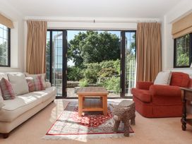 A living room with a couch, table, and chair at Sandsgate, near Chagford