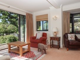 A living room with a sofa, armchair, and coffee table at Sandsgate near Spinster's Rock, near Chagford