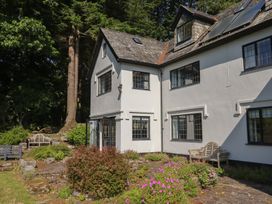 A garden with a house and seating area at Sandsgate near Chagford