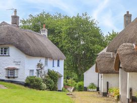 A view of thatched cottages and a green garden at Little Gate Cottage in North Bovey