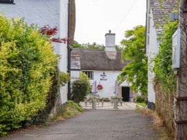 An outdoor area with benches and a sign at Ring of Bells in North Bovey