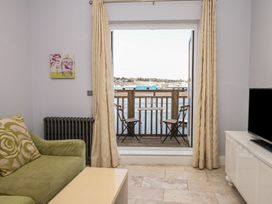 A living room with a sofa and view of the water at The Dolphins in Shaldon