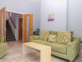 A living room with a green sofa and a small table at The Dolphins in Shaldon