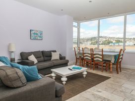 A living room with a sofa and dining table at The Dolphins in Shaldon
