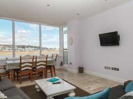 A living room with a dining area and television at The Dolphins in Shaldon