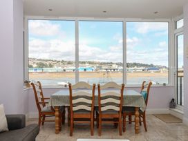 A dining room with a table and chairs overlooking the coast at The Dolphins in Shaldon