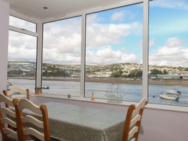 A dining room with a table and chairs overlooking a river at The Dolphins in Shaldon
