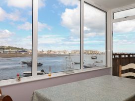 A conservatory with a view of the water and boats at The Dolphins in Shaldon