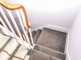 A staircase with a wooden handrail at The Dolphins in Shaldon