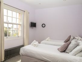 A bedroom with two single beds and a television at The Dolphins in Shaldon