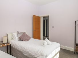 A bedroom with two beds and a door at The Dolphins in Shaldon