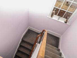 A staircase with a handrail and a window at The Dolphins in Shaldon