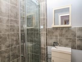 A bathroom with a shower enclosure and a mirror at The Dolphins in Shaldon
