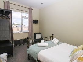 A bedroom with a bed and window at The Dolphins in Shaldon