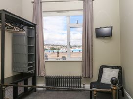 A bedroom with wardrobe and television at The Dolphins in Shaldon