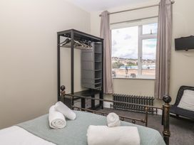 A bedroom with a bed and clothes rack at The Dolphins in Shaldon