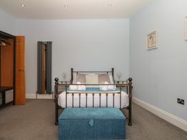 A bedroom with a bed and wardrobe at The Dolphins in Shaldon
