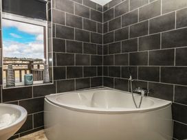A bathroom featuring a bathtub and a window at The Dolphins in Shaldon