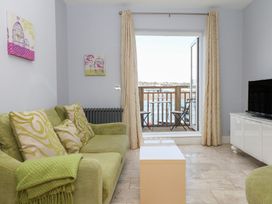 A living room with a sofa and a television at The Dolphins in Shaldon