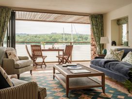 A living room with a sofa and armchair at Sandridge Boathouse in Stoke Gabriel