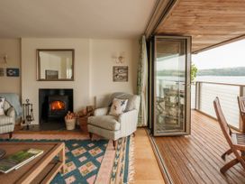 A living room with a fireplace and sliding door at Sandridge Boathouse in Stoke Gabriel