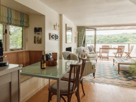 A living room with a table and chairs at Sandridge Boathouse Stoke Gabriel