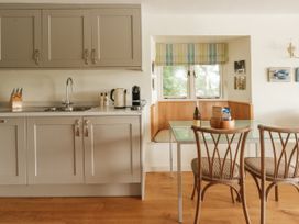 A kitchen with cabinets, sink and dining area at Sandridge Boathouse Stoke Gabriel