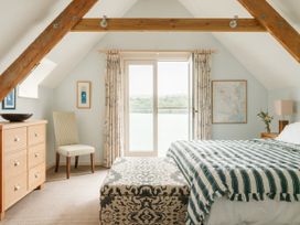 A bedroom with a bed and dresser at Sandridge Boathouse in Stoke Gabriel