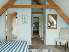 A bedroom with a bed and a chair at Sandridge Boathouse in Stoke Gabriel