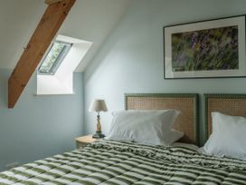 A bedroom with a bed and a lamp at Sandridge Boathouse Stoke Gabriel