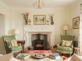 A living room with a fireplace and chairs at Sandridge Barton Stoke Gabriel