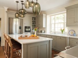 A kitchen with an island and cabinets at Sandridge Barton Stoke Gabriel