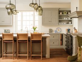 A kitchen with bar stools and cabinets at Sandridge Barton Stoke Gabriel