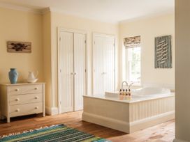 A bathroom with a bathtub and cabinet at Sandridge Barton in Stoke Gabriel