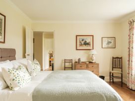 A bedroom with a bed and chair at Sandridge Barton in Stoke Gabriel